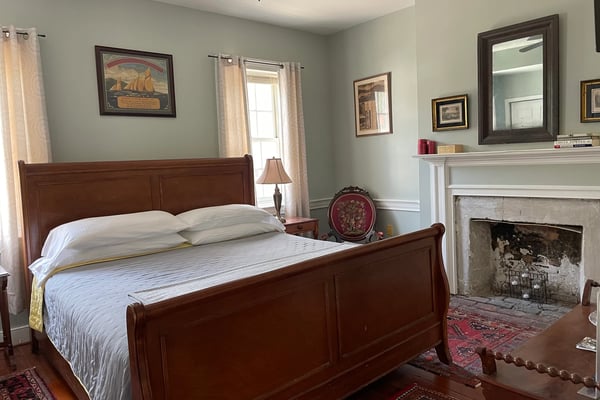 Bedroom with queen bed, black upholstered headboard, stone accent wall, and bedside lamps